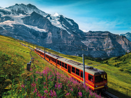 Electric passenger train and snowy Jungfrau mountains in backgro